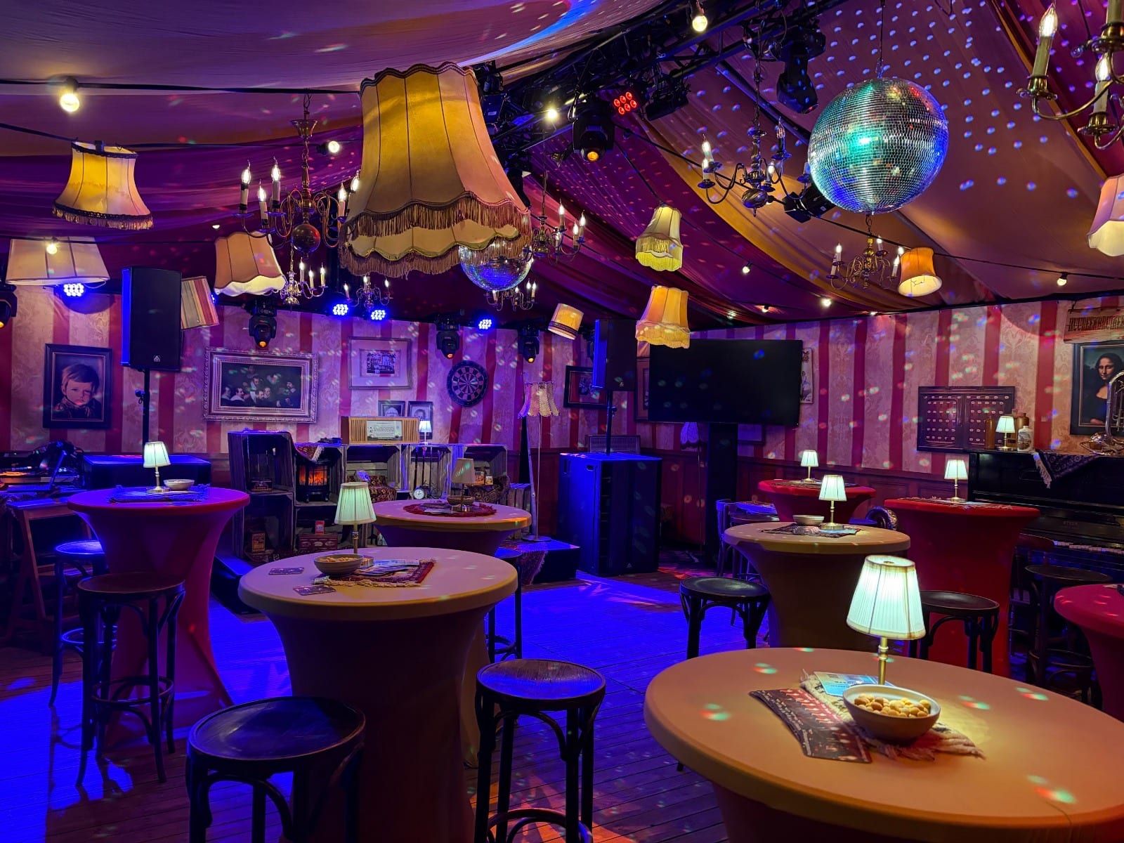 Statafels met tafellampjes, schemerlampen en een discobal in de kroeg